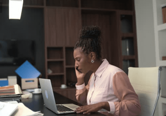 A Person Sitting at a Desk With a Laptop
