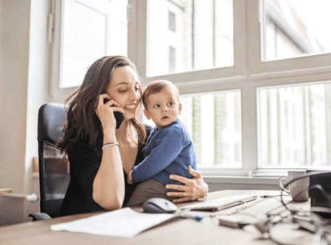 A Person Holding a Baby While Talking on a Phone